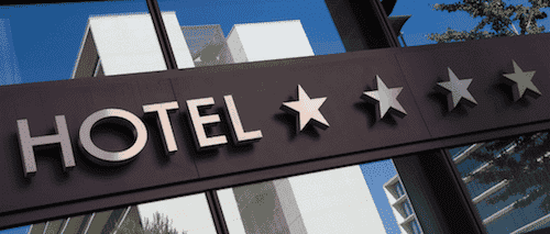 Exterior of a hotel showing four stars. 